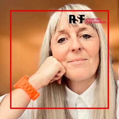 Närbild av Sara med grått hår som vilar huvudet mot handen, mot en varm orange bakgrund, med en röd ram och Reportrar utan gränsers logo i hörnet.