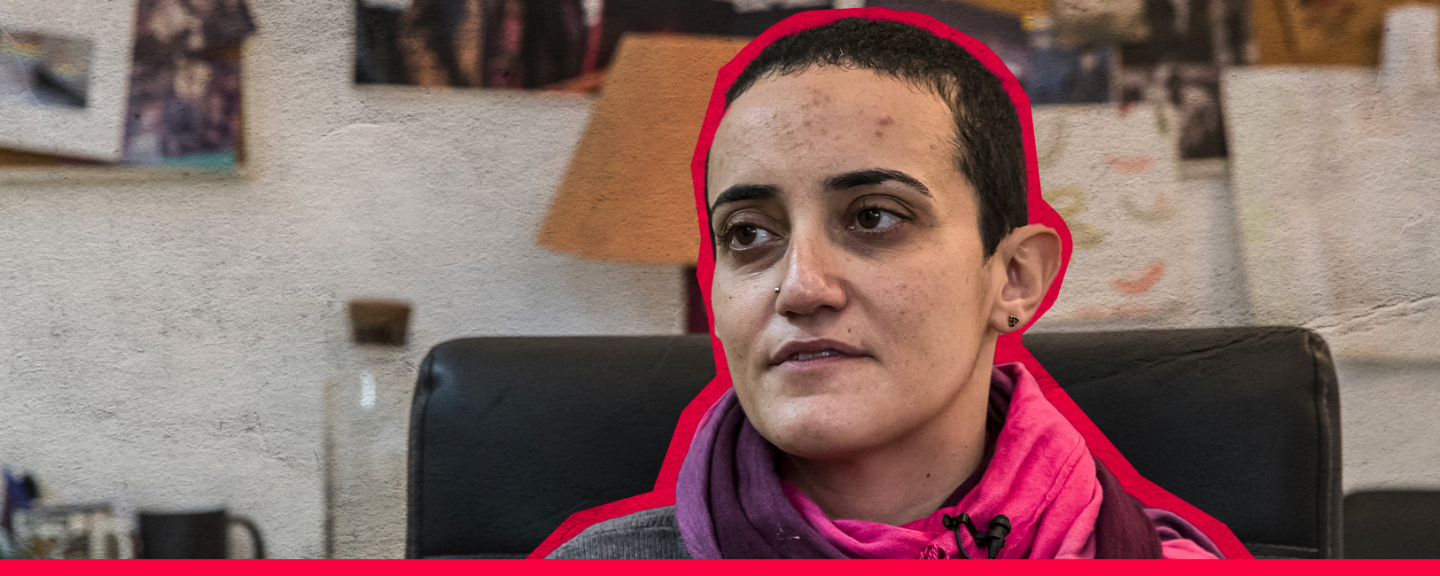 Porträtt av journalisten Lina Attalah, som sitter i en fåtölj med rosa halsduk och är markerad med en röd kontur.